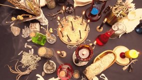 Occult and esoteric witch doctor still life. Halloween background with magic objects. Black candles, human skull, teeth, and potions vials on witch table. Mystic witchery with weeds. - Powered by Shutterstock - Get 15% off with code: PIKWIZARD15