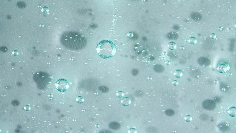 Macro Shot of air Bubbles in Transparent Cosmetic Liquid Gel Cream. Blue Cosmetic Fluid texture With Bubbles. Slow motion 