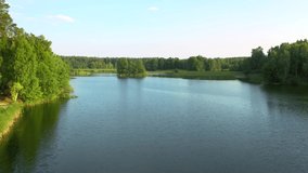 Splendid bird's eye view of a calm lake and green forests on a sunny day. Location place Small Polissya, Ukraine, Europe. Cinematic aerial shot. Discover the beauty of earth. Filmed in 4k drone video.