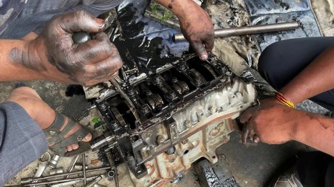 professional mechanic repairing diesel car engine. mechanic disassemble engine piston and connecting rod for repair. 