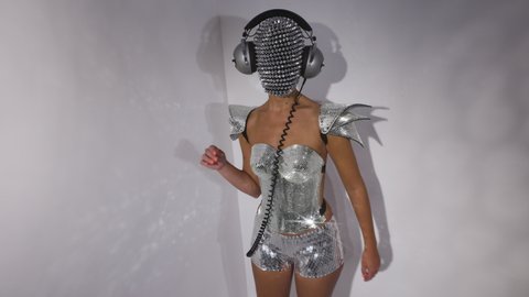 Mrs disco woman with a shiny mirror effect face wearing headphones and silver discoball top