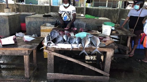 Negombo, Sri Lanka - September 29 2021: Fish market with street seafood sales, tuna fresh fish cutting process in local fish market in negombo sri lanka, Fisherman is cutting fresh seafood tuna fish