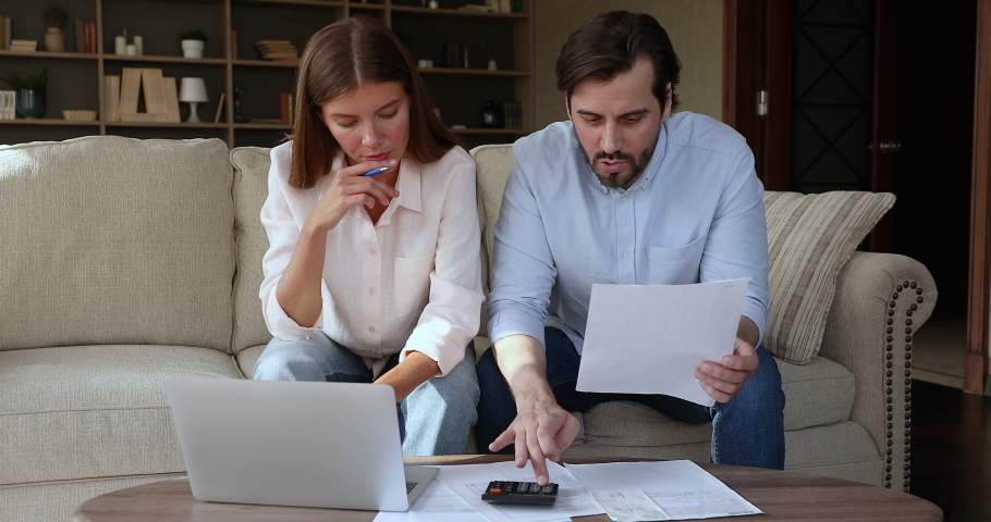 Nervous stressed millennial husband wife concerned with finance problems detect family budget deficit confused of too high business costs. Distressed family couple troubled with tax loan mortgage debt Royalty-Free Stock Footage #1080114272
