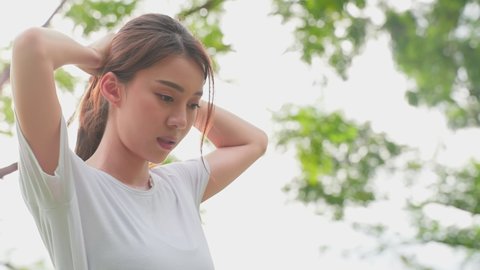Asian sport woman tie hair making ponytail ready to exercise in garden. Attractive athlete girl in sportswear exercise by jogging workout run on street outdoor for health in the evening at public park
