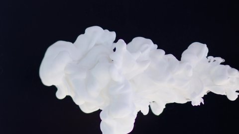 White paint drops in water on a black background, abstract and beautiful wave of ink. 8K downscale, slow motion. Filmed on cinema camera, 4K.