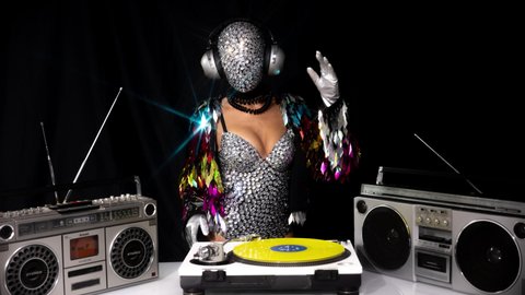 Mrs disco woman with a shiny mirror effect face wearing headphones and Djing on turntables