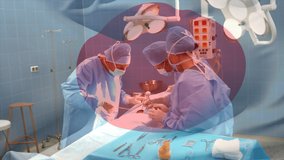 Animation of flag of japan over surgeons in operating theatre. global medicine, healthcare services during covid 19 pandemic concept digitally generated video.