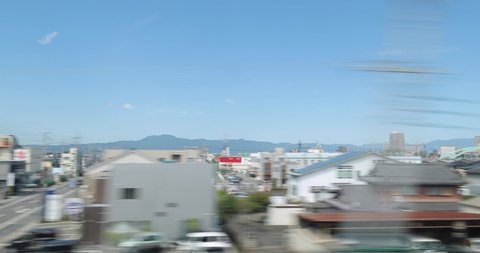 Train journey with high speed train in Japan, view from window, town whizzing by, journey from Kyoto to Tokyo