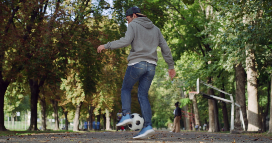 Action Footage Outdoors with Professional Soccer Athlete Performing Freestyle Tricks with a Ball. Confident Young Footballer Showing Off Juggling Skills on a Summer Day in a Public Park | Shutterstock HD Video #1080144725