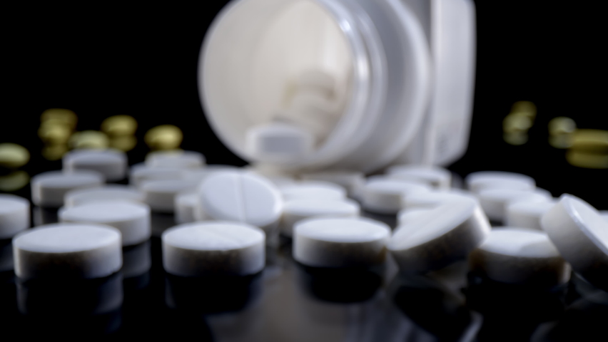 Macro shot of medications pills and drugs spilled out of pill container. Pills and drugs Pharmaceutical Industry. Probe lens shot Medicines. Royalty-Free Stock Footage #1080147455