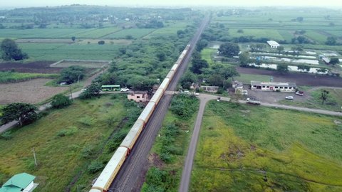 Drone footage of a passenger train hauled by an electric locomotive at Uruli near Pune India.