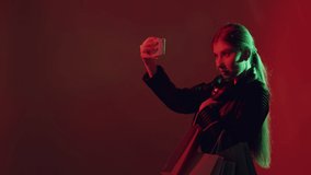 Black Friday shopping. Neon light girl. Cyber monday. Shopaholic lifestyle. Glamour woman with bags taking selfie on mobile phone on dark night red color copy space background. - Powered by Shutterstock - Get 15% off with code: PIKWIZARD15