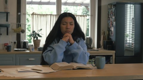 Hispanic girl sitting and praying to God, reading Scripture bible verses, receiving holy spirit in the morning. Christianity