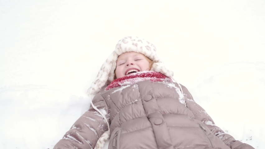 Girl falling on snow at home backyard