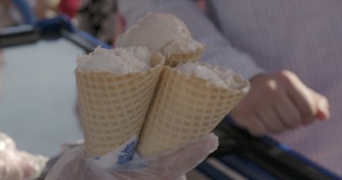 belarus,minsk,2021.  seller puts ice cream in a waffle cone and gives the buyer ice cream