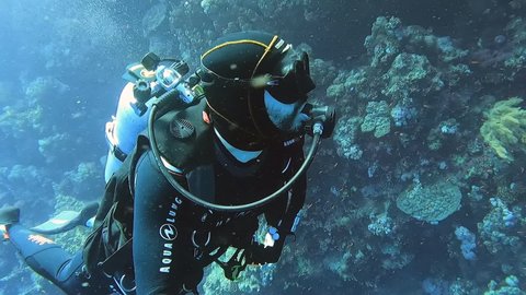 Noumea , France - 06 08 2021: Noumea, New Caledonia - June 2021: scuba divers swimming along the coral reef