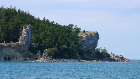 Wide view of rauk cliffs by water at Gotland in Sweden in summer