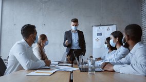 Business motivation. Confident boss talking to his coworkers at office, greeting them after end of covid-19 quarantine and reopening, everyone wearing protective face masks, zoom in, slow motion - Powered by Shutterstock - Get 15% off with code: PIKWIZARD15