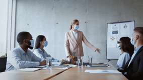 Employment after pandemic. Young arab man manager in face mask carrying box with personal belongings, group of diverse coworkers and team leader greeting him at office, zoom in shot, slow motion - Powered by Shutterstock - Get 15% off with code: PIKWIZARD15
