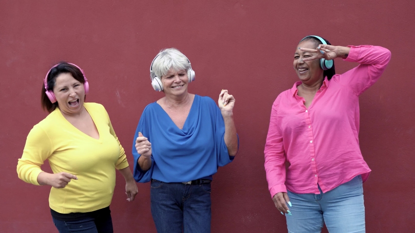 Happy senior women dancing in the city - elderly people and friendship concept