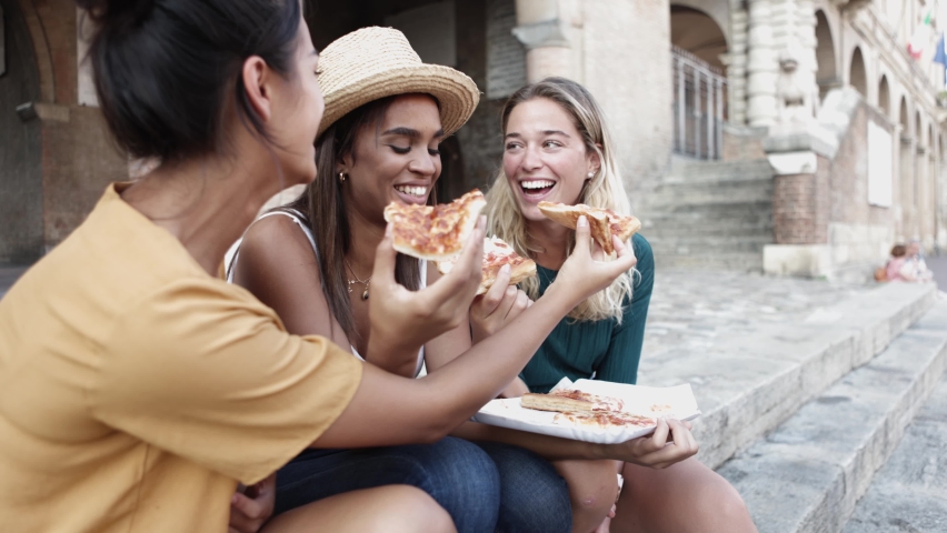 Three cheerful multiracial women eating pizza in the street - Young people lifestyle and summer vacation concept Royalty-Free Stock Footage #1080188762