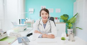 telemedicine concept - close up of asian female doctor wearing headset has video chat to you in hospital