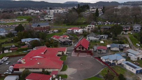Ohinemutu, Rotorua - Aerial pull back from Te Papaiouru Marae and square reveal Anglican Church and War Memorial on lakeshore. New Zealand