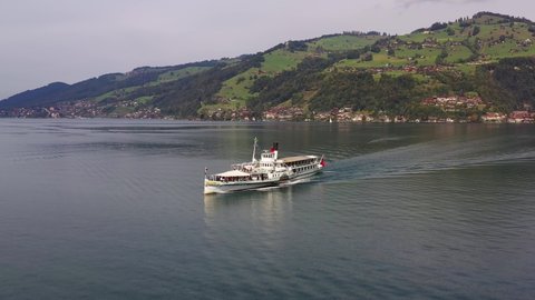 Aerial drone footage of anostalgic steamboat cruise ship that sails on lake Thun toward Spiez in the Bernese Oberland in Switzerland
