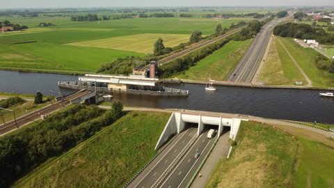 Aqueduct water bridge with boats passing traffic on the highway below in Friesland, The Netherlands.