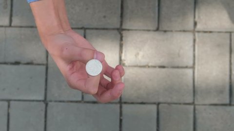Male hand tosses a coin and catches it, slow motion