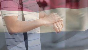 Animation of flag of netherlands waving over man wearing face mask during covid 19 pandemic. global covid 19 pandemic concept digitally generated video.