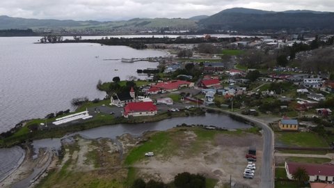 Small living Maori village with historic buildings and War Memorial - Aerial view of Ohinemutu Rotorua city suburb on lakeshore
