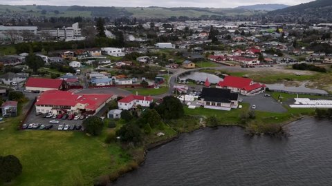 Ohinemutu historic traditional Maori village and original settlement on Lake Rotorua, New Zealand. Aerial tilt down rising drone shot
