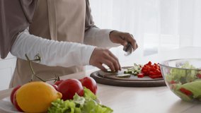 Muslim Female In Hijab Cutting Vegetables Making Salad Cooking In Modern Kitchen Indoors. Unrecognizable Islamic Housewife Preparing Dinner For Family At Home. Cropped, Tracking Shot