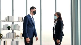 2 caucasian business people wearing masks and greet each other with their elbows touching each other. instead of touching with hands to reduce the spread of corona virus or covid-19 in the workplace. - Powered by Shutterstock - Get 15% off with code: PIKWIZARD15