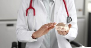 Doctor mammologist holding silicone breast implant 4k movie