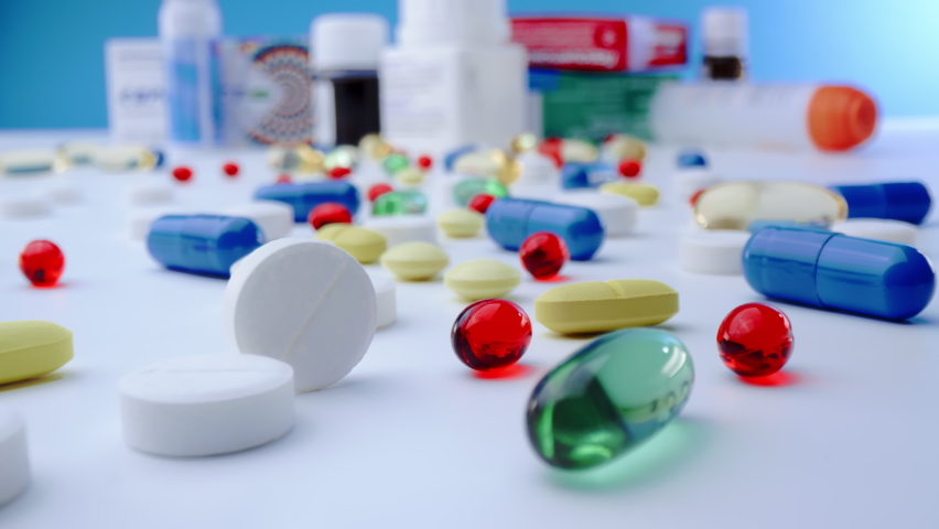 Macro shot of medications pills and tablets spilled out of pill container. Multicolored drugs Probe lens shot. Royalty-Free Stock Footage #1080228251