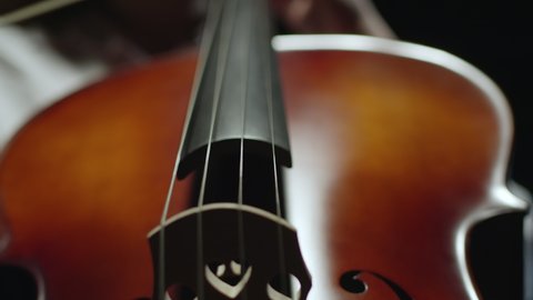 Cello player. Cellist hands playing cello with bow. Violoncello orchestra musical instrument closeup