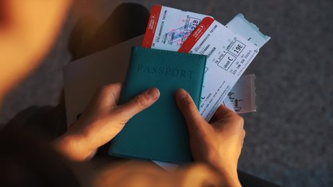 YAROSLAVL, RUSSIA - DECEMBER 23, 2015:Close-up of passenger looking at plane tickets and passport. Tourist checking documents while waiting for flight. Concept of tourism, airport registration.