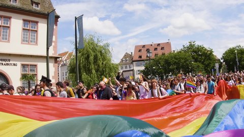 Strasbourg, France - June 2019: Handheld pan over man dancing on gay truck in city center of Strasbourg on a sunny day during Lesbian Gay Bisexual Transgender LGBT visibility march pride FestiGays