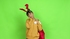 Young woman with christmas hat making sleep gesture. Adorable and sweet expression over isolated background. Green screen chroma key