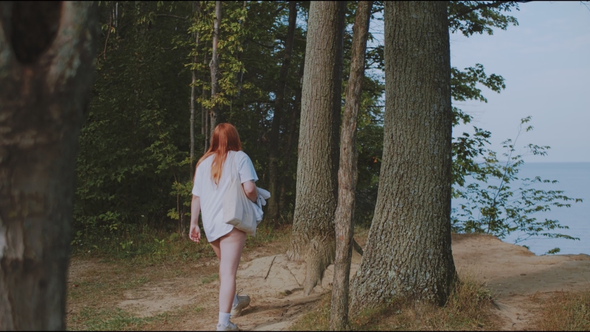 Girl on cliff looking at ocean