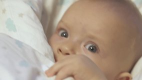 Baby falling asleep after feeding, caucasian six month old infant in baby rocking chair close up. High quality 4k footage