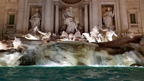 Incredible real time low angle view of Fontana di Trevi fountain in Rome at night with nocturnal illumination. Italy