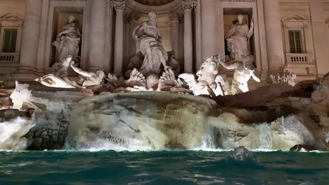 Incredible low angle view of Fontana di Trevi fountain in Rome at night with nocturnal illumination. Italy