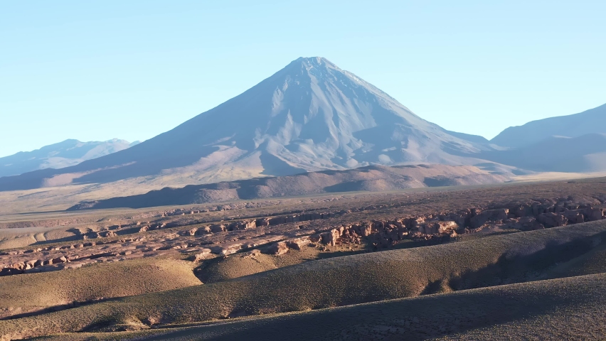 Aerial pull away shot of the volcano Volcan Licancabur east of the town San Pedro de Atacama in the north of Chile in the Atacama desert at sunrise