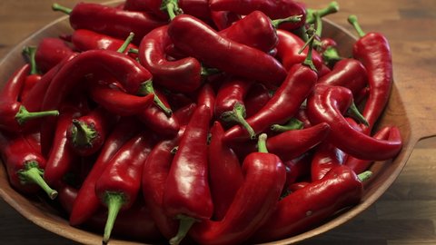 A wooden bowl of ripe red New Mexico Chile ready to become part of a spicy and delicious southwest dish. slide pan motion in 4K.