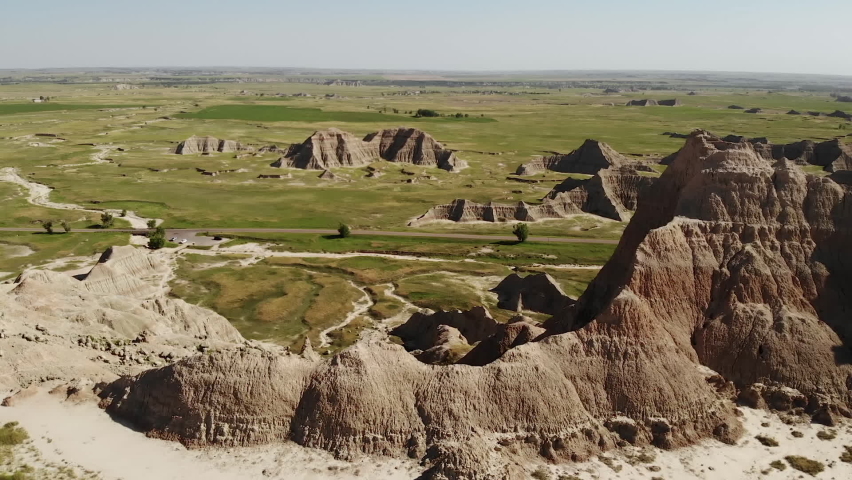 Landscape of Badlands National Park, South Dakota USA. Drone Aerial View, Steep Eroded Cliffs, Green Prairie and Countryside Road on Sunny Day