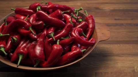 A wooden bowl of ripe red New Mexico Chile ready to become part of a spicy and delicious southwest dish. slide pan motion 4K.