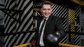 Portrait of a happy businessman man in boxing gloves in a boxing ring, he raises his hands up. The concept of success in business. - Powered by Shutterstock - Get 15% off with code: PIKWIZARD15